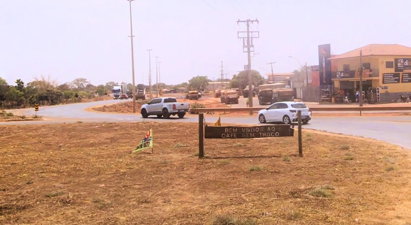 Foto de uma avenida em uma cidade do interior com carros passando.