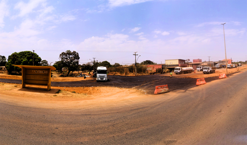 Estrada de terra com céu azul ao fundo.